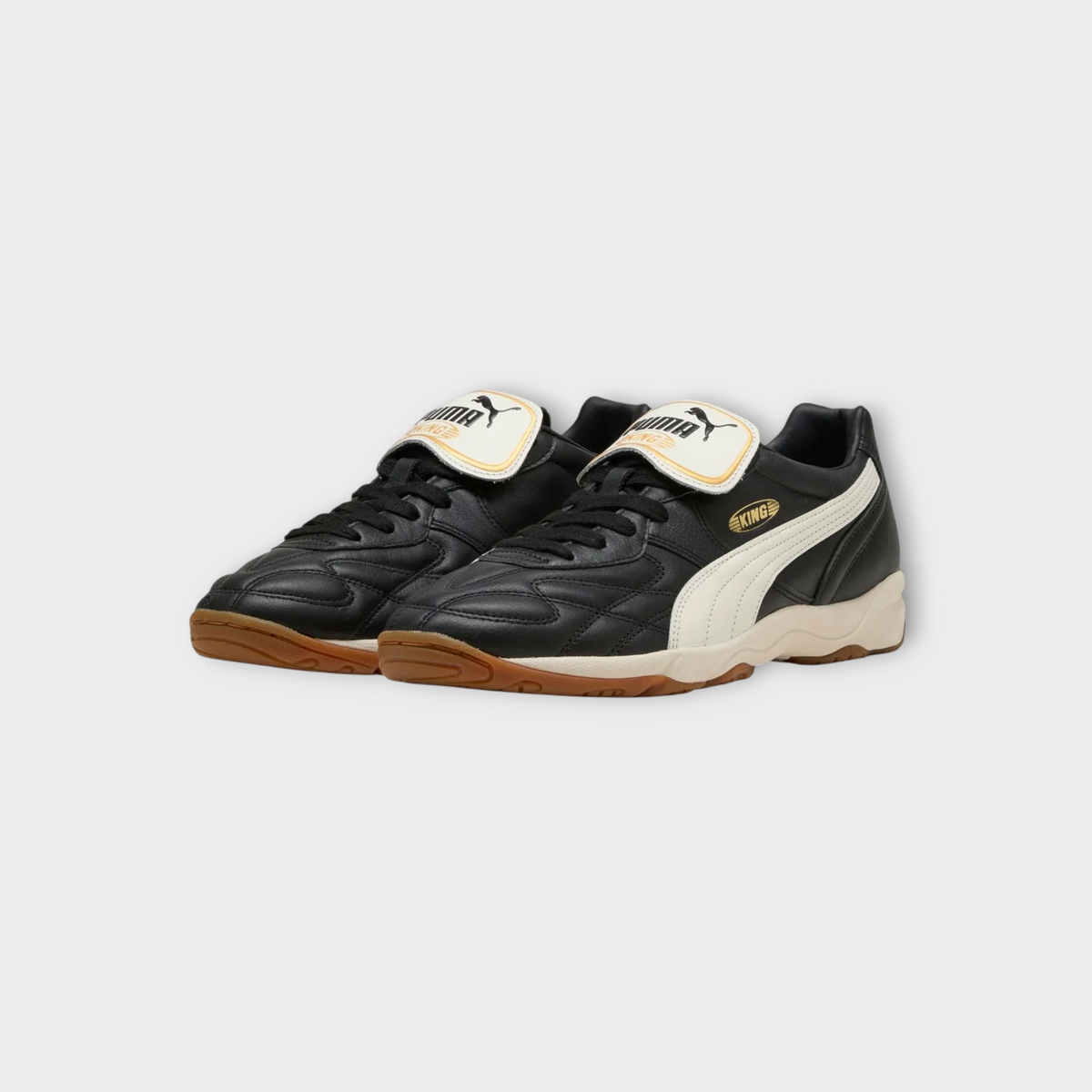 Drop Puma King indoor sneakers in black leather with warm white accents and a gum rubber sole.