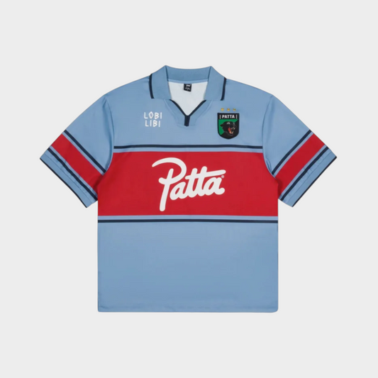 Drop Patta Legacy football jersey in faded denim blue with a red chest stripe, white logo, and panther crest emblem.