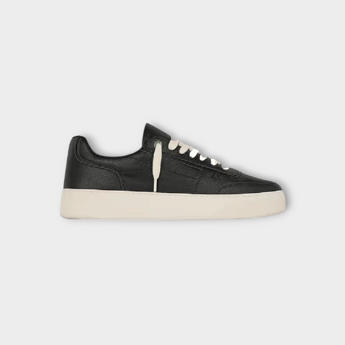 Drop Represent Initial black leather sneaker with a thick white rubber sole and white laces, side view.
