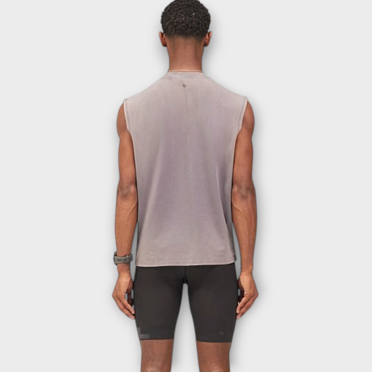 Back view of a man wearing a Drop 247 Angel graphic tank top in graphene grey, paired with black athletic shorts.