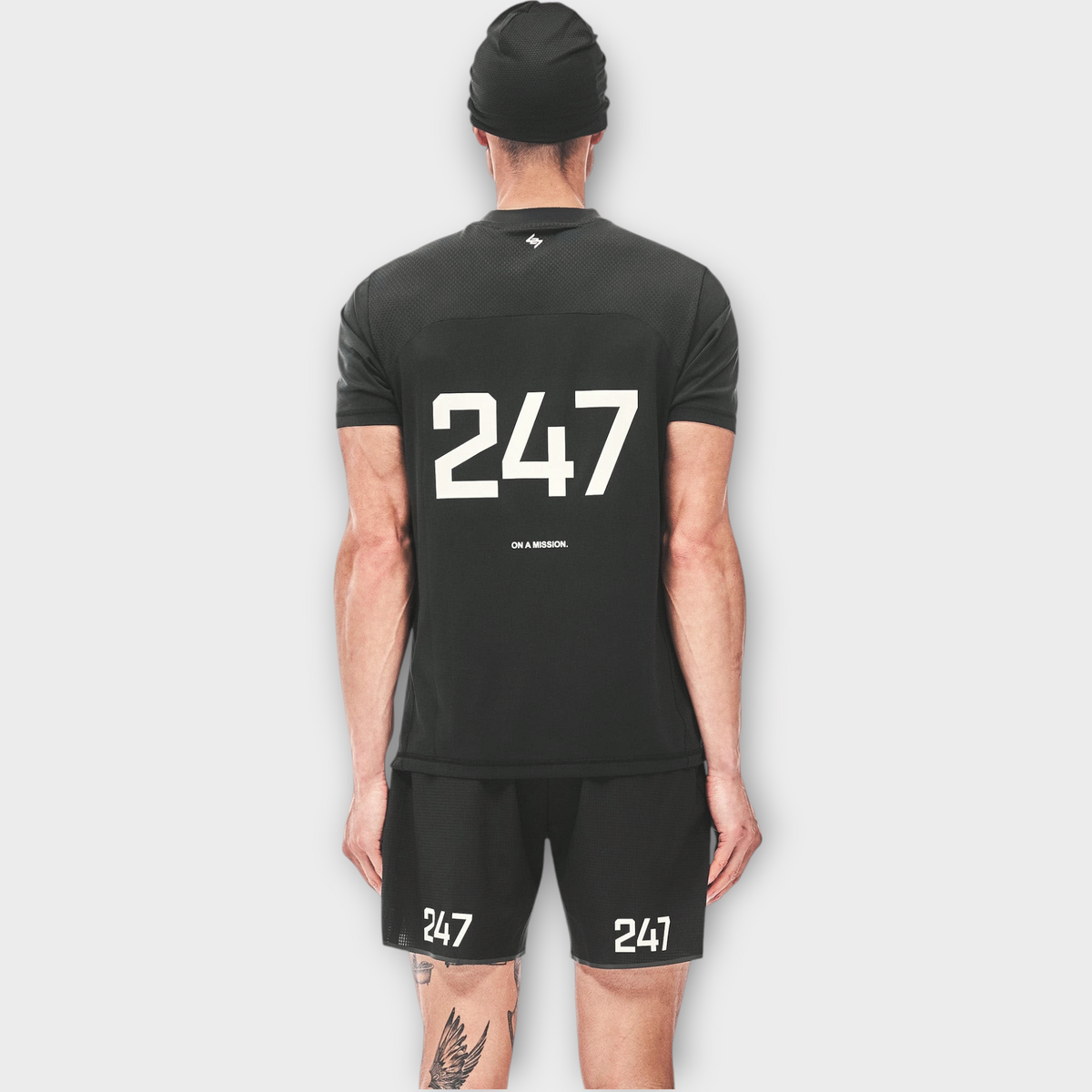 Drop 247 FW26 Numbers T-shirt in jet black with white graphic print, worn by a model from the back view.