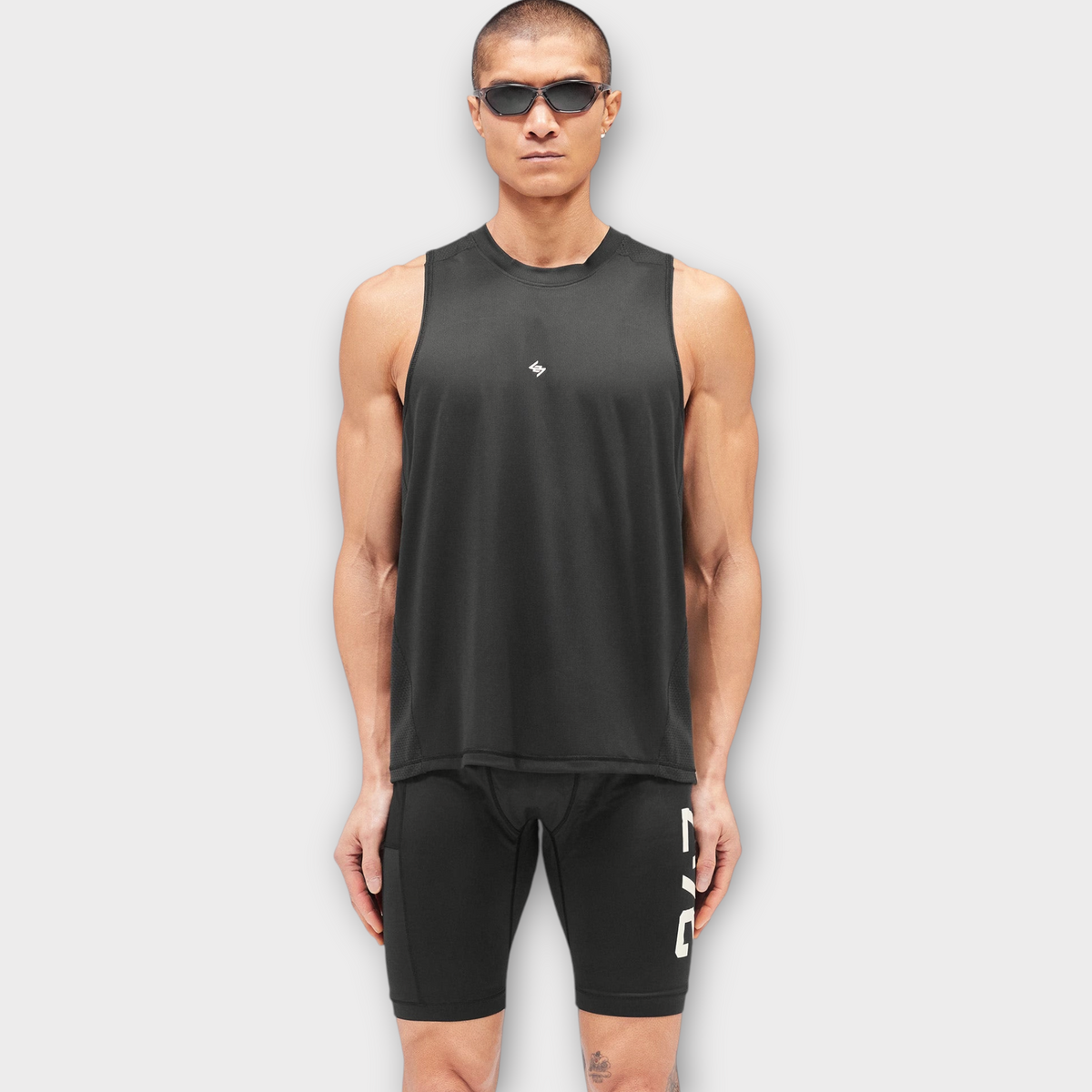 Drop 247 FW26 Numbers vest in jet black worn by a model with sunglasses, featuring a lightweight athletic fit.