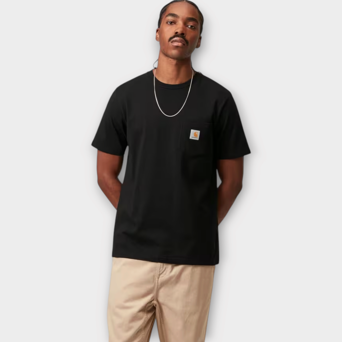 Drop Carhartt WIP black short sleeve cotton t-shirt with a chest pocket and logo patch worn by a male model