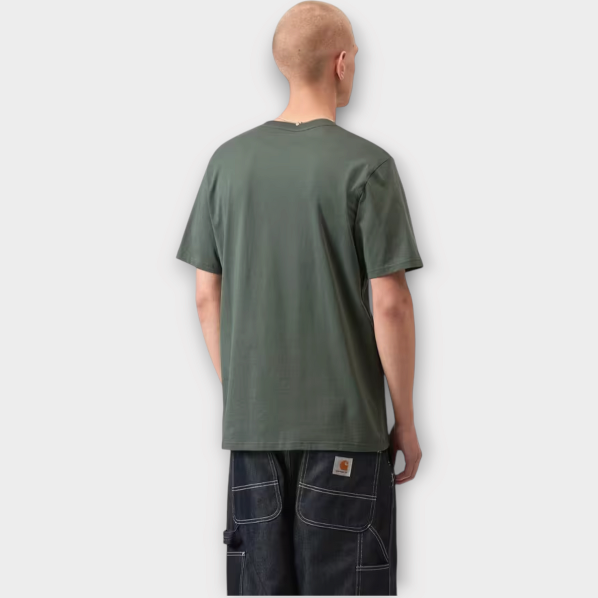 Back view of a man wearing a Drop Carhartt WIP smoke green cotton jersey t-shirt with dark denim jeans