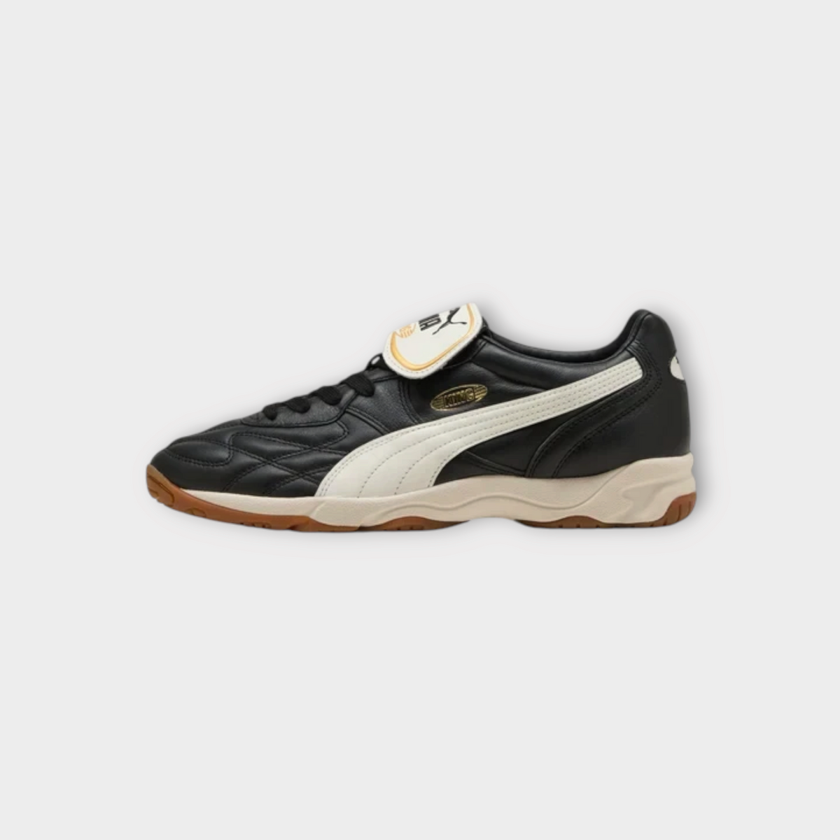 Drop Puma King indoor sneakers in black leather with warm white side stripe and gum rubber sole, side view