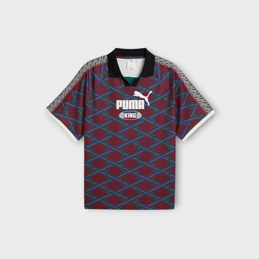 Drop Puma KING jersey in ruby shimmer with a geometric pattern, black polo collar, and white sleeve trim.